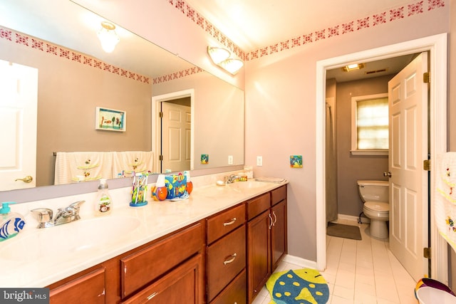 bathroom with toilet, double vanity, a sink, and tile patterned flooring