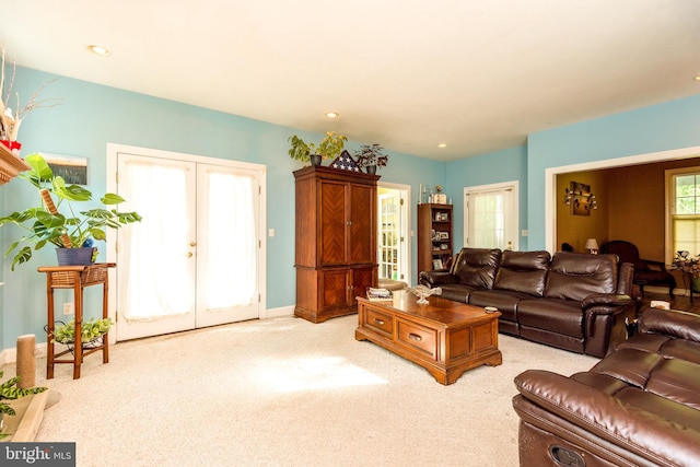 living area with french doors, baseboards, recessed lighting, and light carpet