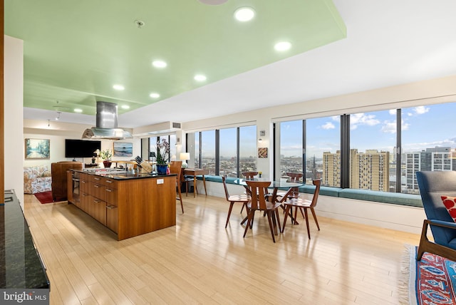 2001 Hamilton St Unit 1914, Philadelphia, PA 19130 - kitchen with island exhaust hood, open floor plan, brown cabinets, light wood-style floors, and recessed lighting
