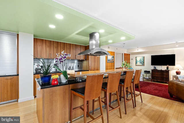 2001 Hamilton St Unit 1914, Philadelphia, PA 19130 - kitchen featuring island exhaust hood, light wood-style flooring, recessed lighting, open floor plan, and brown cabinets