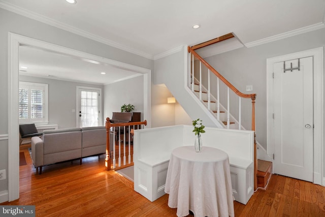 entrance foyer with recessed lighting, light wood-type flooring, ornamental molding, and stairs