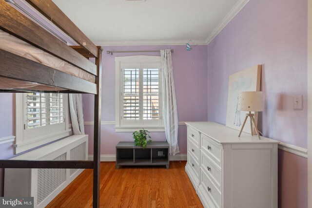 bedroom featuring crown molding, visible vents, baseboards, and light wood-style floors