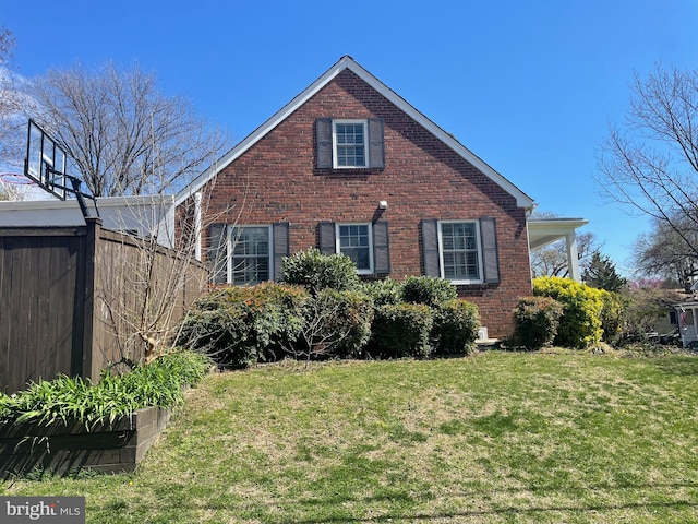 view of front of house with a front yard, fence, and brick siding