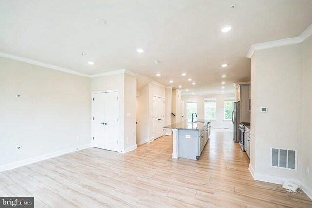 4418 Roland Heights Ave, Baltimore, MD 21211 - kitchen featuring crown molding, freestanding refrigerator, a kitchen island with sink, light wood finished floors, and recessed lighting