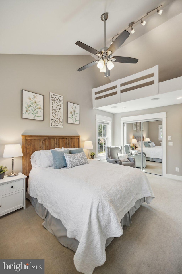 bedroom featuring a ceiling fan, high vaulted ceiling, and light colored carpet