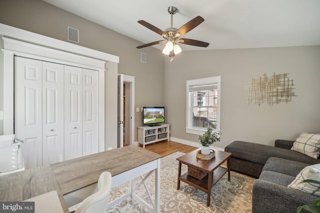 living room featuring visible vents, a ceiling fan, wood finished floors, and lofted ceiling