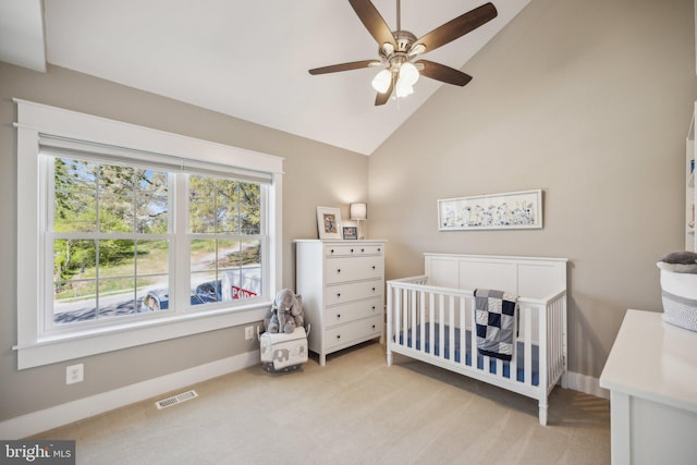 bedroom with light colored carpet, visible vents, a crib, baseboards, and high vaulted ceiling