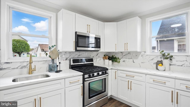 2910 Salisbury Ave, Baltimore, MD 21219 - kitchen with stainless steel appliances, white cabinetry, a sink, and decorative backsplash