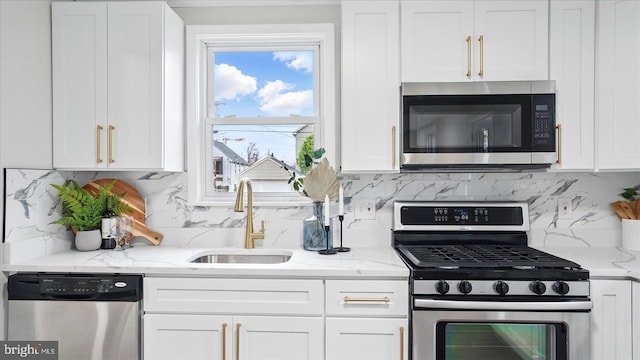 2910 Salisbury Ave, Baltimore, MD 21219 - kitchen with stainless steel appliances, white cabinets, a sink, and light stone counters