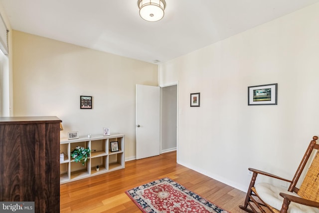 living area featuring baseboards and wood finished floors