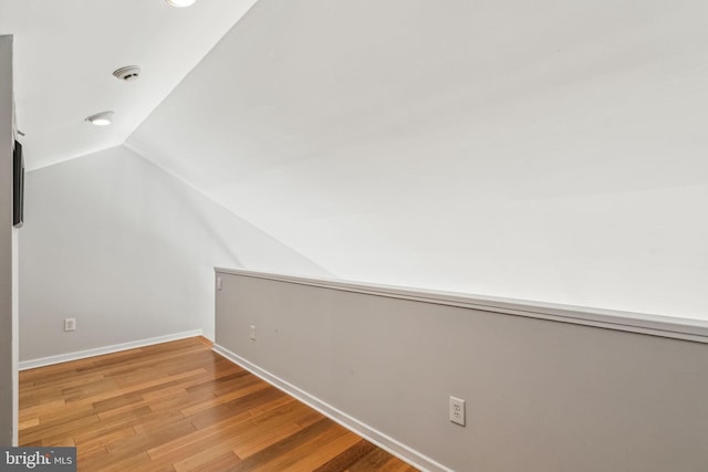 additional living space with recessed lighting, vaulted ceiling, wood finished floors, and baseboards