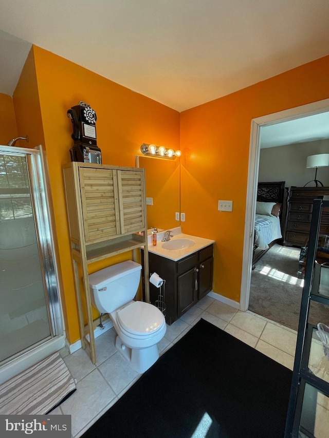 ensuite bathroom with vanity, toilet, tile patterned floors, baseboards, and a shower stall