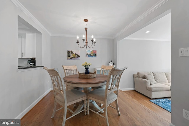 10945 Harpers Square Ct, Reston, VA 20191 - dining room featuring light wood-style flooring, a chandelier, baseboards, ornamental molding, and recessed lighting