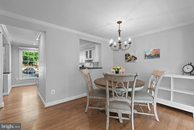 10945 Harpers Square Ct, Reston, VA 20191 - dining space featuring light wood-type flooring, a chandelier, crown molding, and baseboards