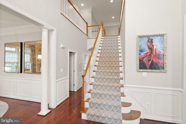43005 Running Ridge Way, Leesburg, VA 20176 - stairway featuring crown molding, a decorative wall, wood finished floors, ornate columns, and wainscoting