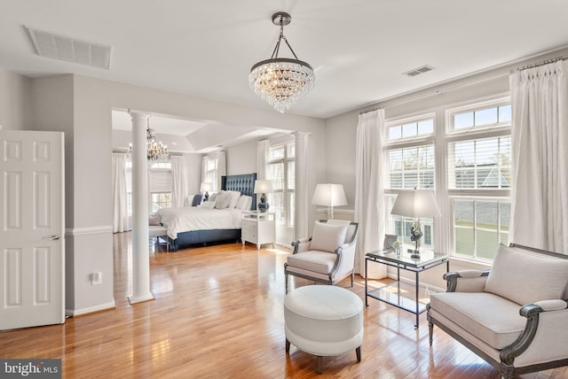 43005 Running Ridge Way, Leesburg, VA 20176 - bedroom featuring a chandelier, wood finished floors, baseboards, and decorative columns
