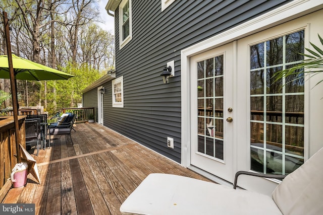 wooden terrace featuring french doors and outdoor dining space