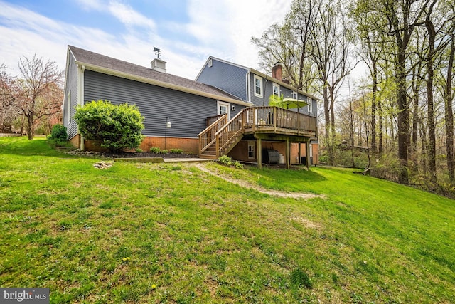 back of house with a chimney, a yard, a deck, and stairs