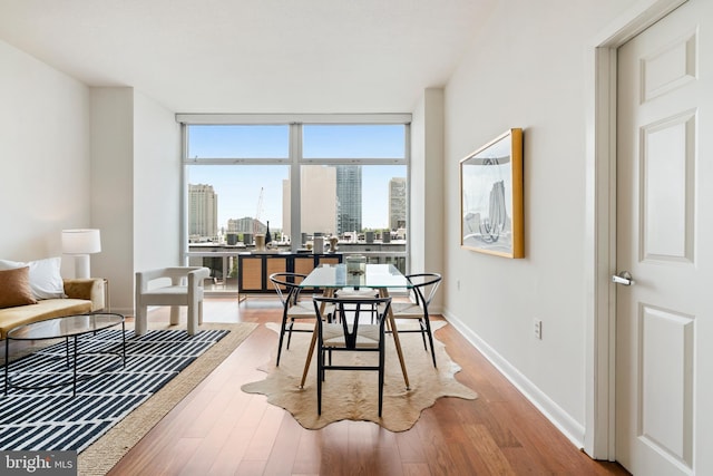 22 S Front St Unit 603, Philadelphia, PA 19106 - dining space with wood finished floors, floor to ceiling windows, a skyline view, and baseboards