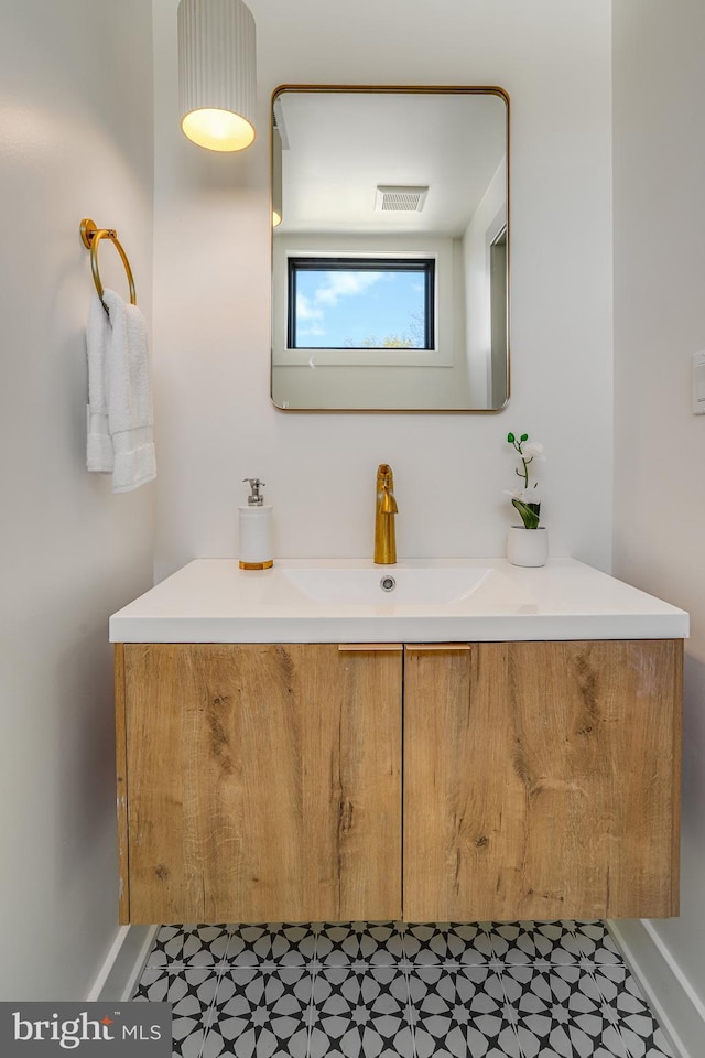 bathroom featuring tile patterned floors, vanity, visible vents, and baseboards