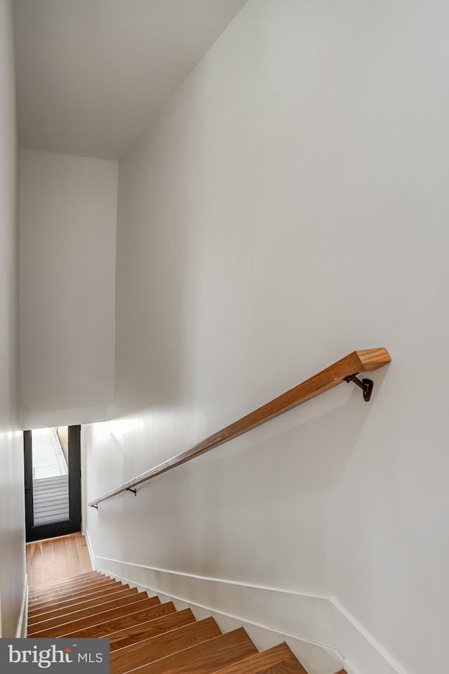 stairway featuring baseboards and wood finished floors