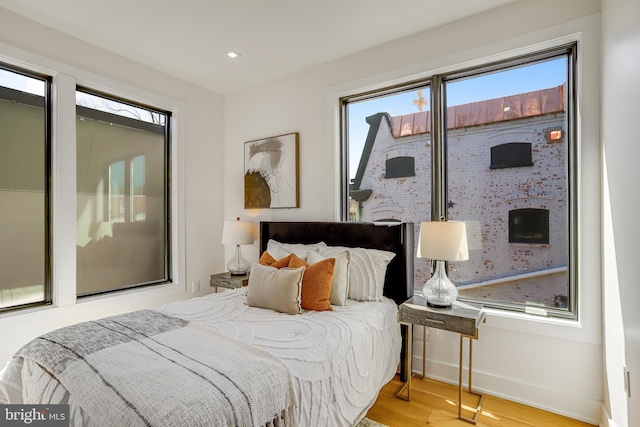 bedroom featuring baseboards, recessed lighting, and wood finished floors