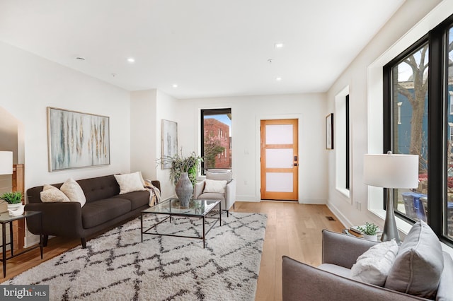 living area featuring visible vents, baseboards, recessed lighting, and light wood-style floors