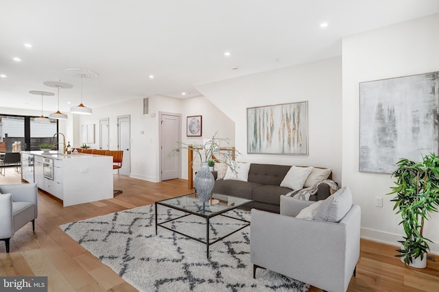 living area featuring recessed lighting, light wood-style flooring, and baseboards