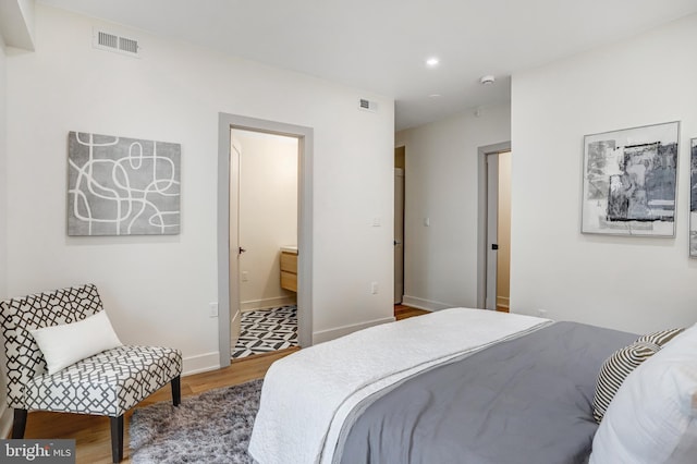 bedroom with wood finished floors, baseboards, visible vents, and recessed lighting