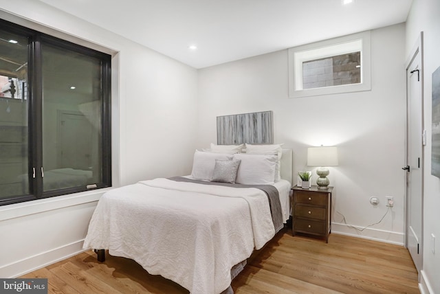 bedroom with light wood-style flooring, baseboards, and recessed lighting