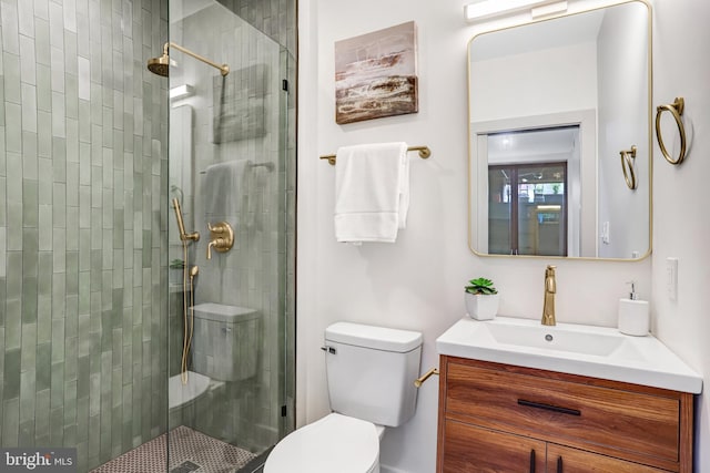 full bathroom featuring toilet, a stall shower, and vanity