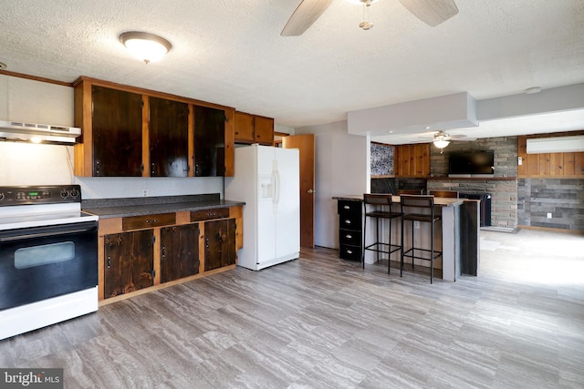 2447 General Potter Hwy, Centre Hall, PA 16828 - kitchen featuring white fridge with ice dispenser, a ceiling fan, under cabinet range hood, range with electric cooktop, and a kitchen breakfast bar