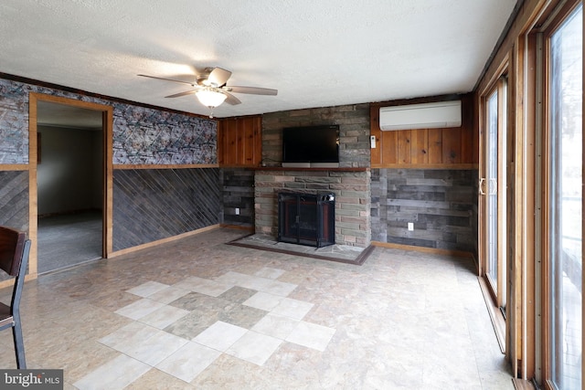 2447 General Potter Hwy, Centre Hall, PA 16828 - unfurnished living room with a wall mounted AC, wood walls, a textured ceiling, ceiling fan, and a fireplace