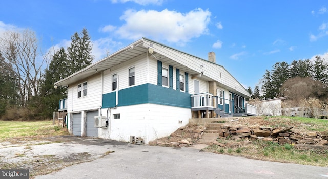 2447 General Potter Hwy, Centre Hall, PA 16828 - view of side of property with a chimney, aphalt driveway, and an attached garage