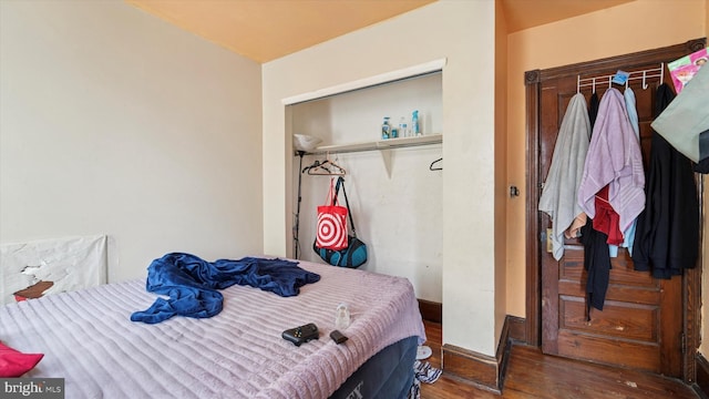 bedroom featuring wood finished floors, a closet, and baseboards