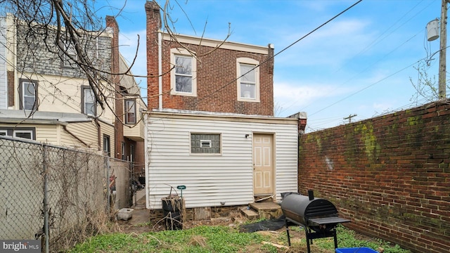 back of house featuring entry steps and fence