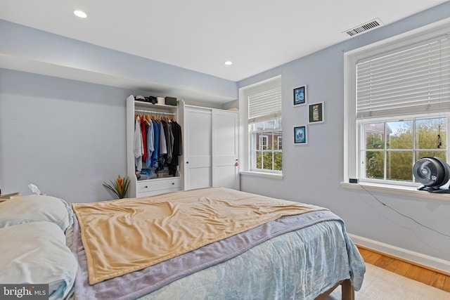 bedroom featuring recessed lighting, visible vents, baseboards, and wood finished floors