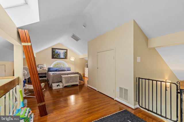 bedroom with visible vents, wood finished floors, and lofted ceiling