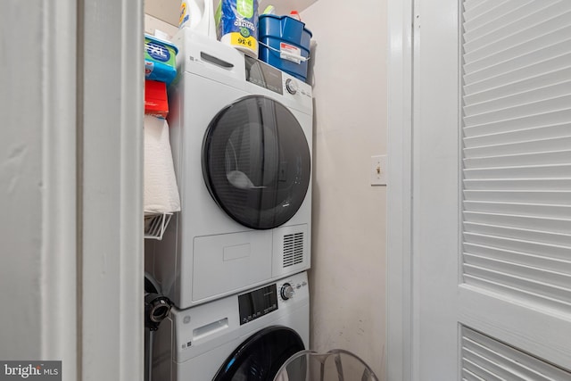 laundry room with stacked washing maching and dryer and laundry area