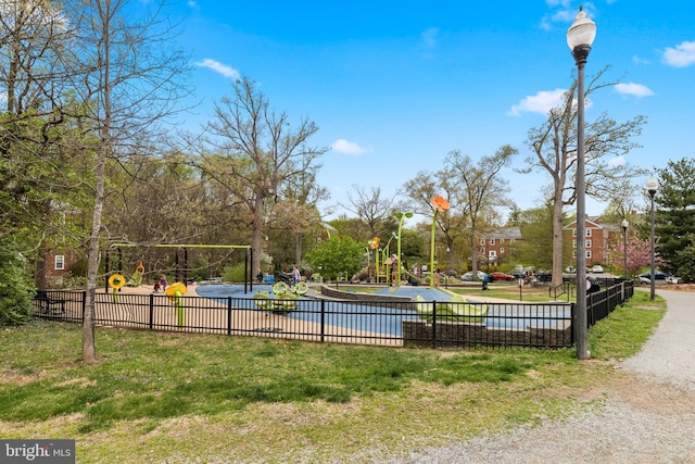 view of property's community with a yard, fence, and playground community