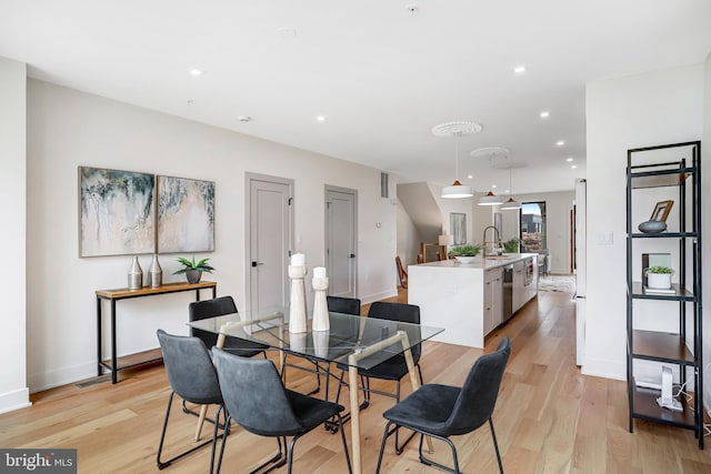 dining space with recessed lighting, light wood-style flooring, and baseboards
