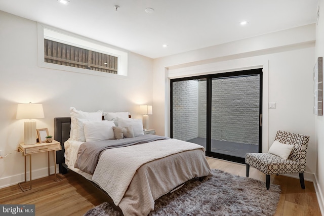 bedroom with light wood-style floors, recessed lighting, access to outside, and baseboards