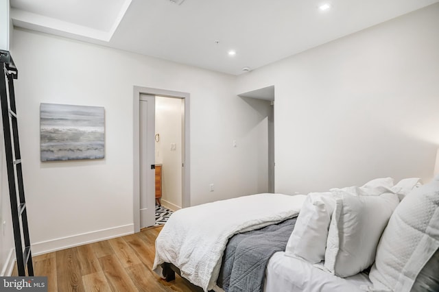 bedroom featuring baseboards, light wood-type flooring, and recessed lighting