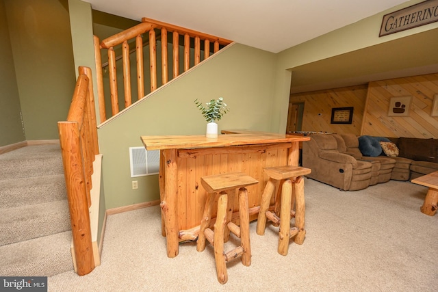 1419 Sandy Shores Rd, Mc Henry, MD 21541 - carpeted dining room with stairway, baseboards, wooden walls, visible vents, and a bar