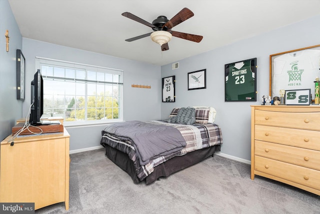 carpeted bedroom featuring baseboards, a ceiling fan, and visible vents
