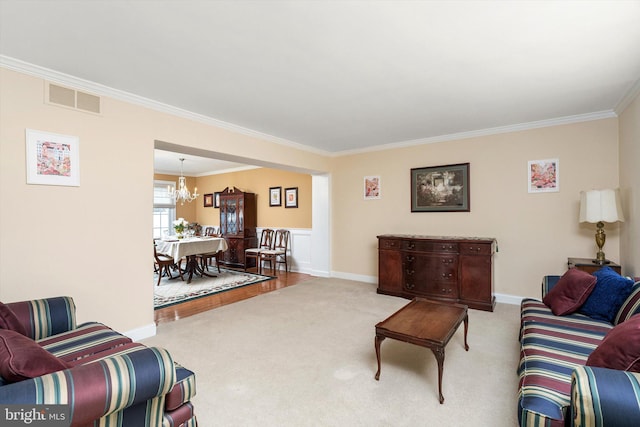 carpeted living area with baseboards, visible vents, a chandelier, and ornamental molding