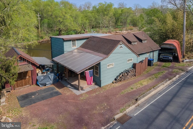 view of front facade with a view of trees and metal roof