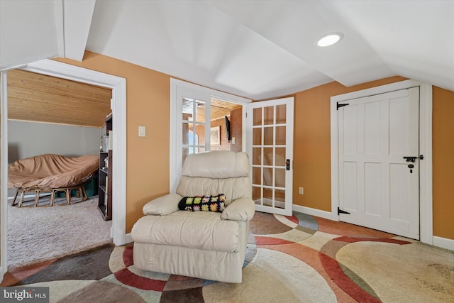 sitting room with carpet flooring, baseboards, and vaulted ceiling