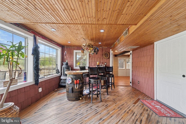 bar with wood-type flooring, wood ceiling, and wooden walls