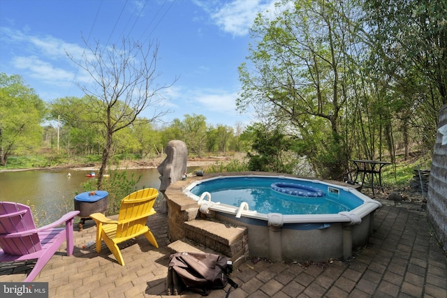 view of swimming pool with a hot tub and a patio area
